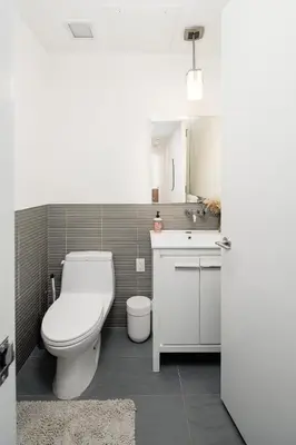 a bathroom with a white toilet and a sink at Luxury 2BD nr Wall St Gym Rooftop w/d in New York