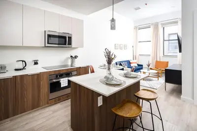 a kitchen and living room with a counter and chairs at Spacious Luxury 2BD Downtown Gym W/D Doorman in New York