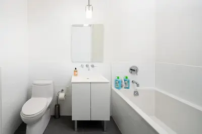 a bathroom with a toilet and a tub and a sink at Spacious Luxury 2BD Downtown Gym W/D Doorman in New York