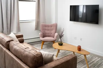 a living room with a couch and a chair at Chic 1BD with Rooftop W/D in Unit Downtown in New York