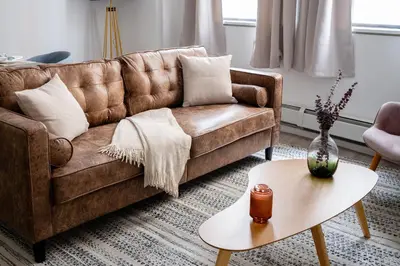 a living room with a brown couch and a table at Chic 1BD with Rooftop W/D in Unit Downtown in New York