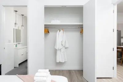 a bathroom with white walls and white towels at Chic 1BD with Rooftop W/D in Unit Downtown in New York