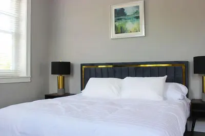 a white bed with white pillows and a picture on the wall at The National Hotel in Frenchtown