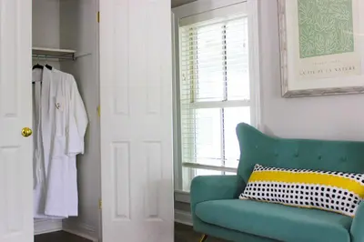 a living room with a green couch and a window at The National Hotel in Frenchtown
