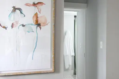 a painting of flowers on a wall next to a mirror at The National Hotel in Frenchtown