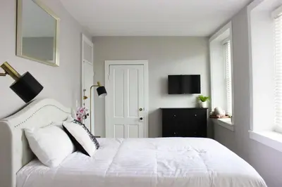 a white bedroom with a white bed and a window at The National Hotel in Frenchtown