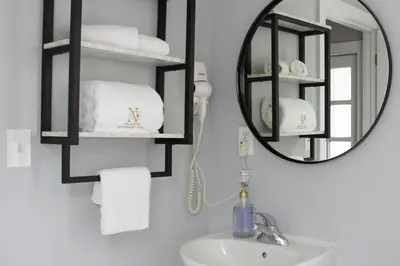 a bathroom with a mirror and a sink with towels at The National Hotel in Frenchtown