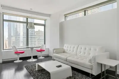 a living room with a white couch and a table at Financial District 1br w WD gym elevator NYC-1376 in New York