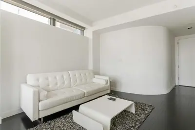 a living room with a white couch and a table at Financial District 1br w WD gym elevator NYC-1376 in New York