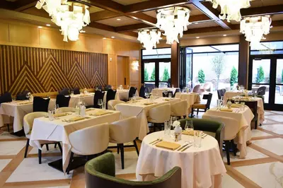 a restaurant with white tables and chairs and chandeliers at The Swiftwater in Swiftwater