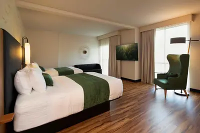 a hotel room with a large bed and a chair at The Swiftwater in Swiftwater