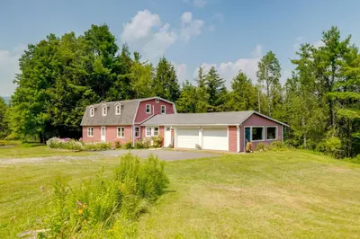 a house on a hill with a yard at Fire Pit and On-Site Pond Wooded Walton Home! in Walton