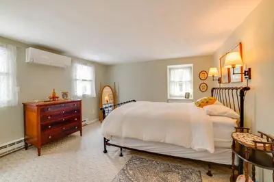 a bedroom with a large bed and a wooden dresser at Fire Pit and On-Site Pond Wooded Walton Home! in Walton