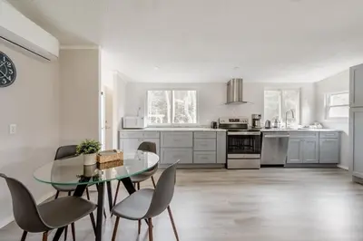 a kitchen with a glass table and chairs at EV Serene Modern Cozy Waterfront Fireplace Cottage in Livingston Manor