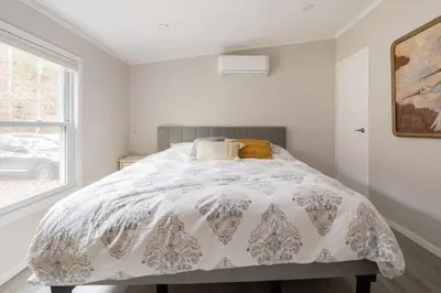 a bedroom with a bed and a window at EV Serene Modern Cozy Waterfront Fireplace Cottage in Livingston Manor