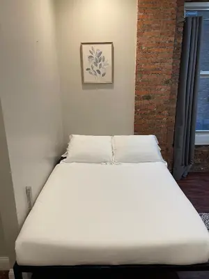 a white bed in a room with a window at Nest 1 bedroom Aparthotel with kitchenette in New York