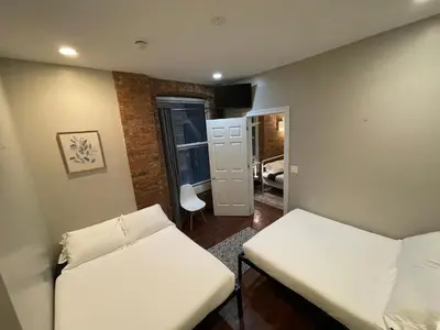 a small room with two beds and a hallway at Nest 1 bedroom Aparthotel with kitchenette in New York