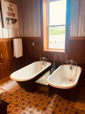 a bathroom with two sinks and a tub and a window at Church Bells in Wyalusing