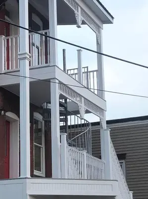 a white house with a white staircase on it at Church Bells in Wyalusing