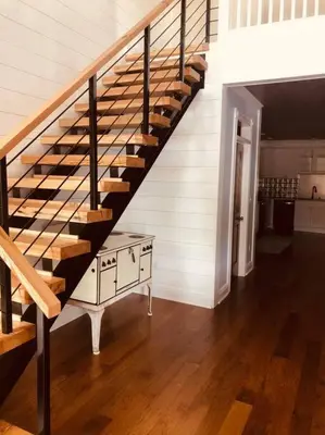 a staircase in a house with a table and a stair case at Church Bells in Wyalusing