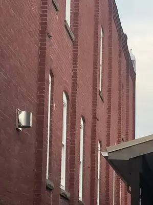 a tall brick building with windows on the side of it at Church Bells in Wyalusing