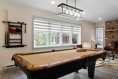 a pool table in a living room with a window at Open Concept & Stylish-HotTub-Sauna-Billiard-Poker-BBQ in East Stroudsburg