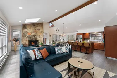 a living room with a blue couch and a kitchen at Open Concept & Stylish-HotTub-Sauna-Billiard-Poker-BBQ in East Stroudsburg