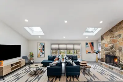 a living room with a blue couch and a fireplace at Open Concept & Stylish-HotTub-Sauna-Billiard-Poker-BBQ in East Stroudsburg