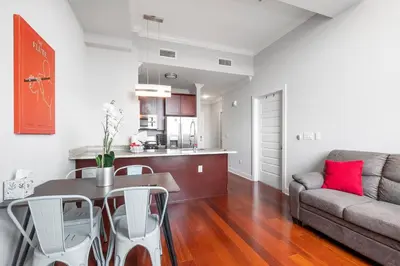a living room with a table and a couch at Grand 1BR with Rooftop Pool & Gym in Philadelphia