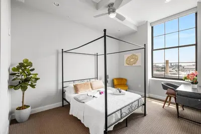 a bedroom with a canopy bed and a table at Grand 1BR with Rooftop Pool & Gym in Philadelphia