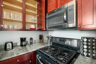 a kitchen with a stove and a microwave at Grand 1BR with Rooftop Pool & Gym in Philadelphia
