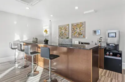 a kitchen with a bar with stools in a room at Grand 1BR with Rooftop Pool & Gym in Philadelphia