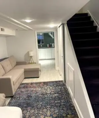 a living room with a couch and a staircase at Northern Liberties Fishtown Central Cozy Quaint in Philadelphia