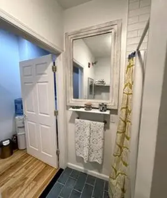 a bathroom with a sink and a mirror and a door at Northern Liberties Fishtown Central Cozy Quaint in Philadelphia