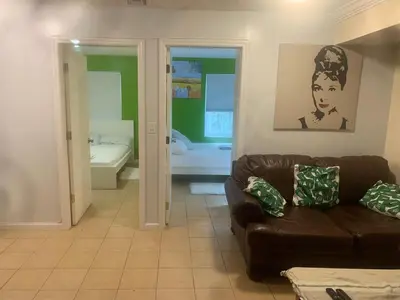 a living room with a brown couch and a bathroom at The Green Place of Newark in Newark