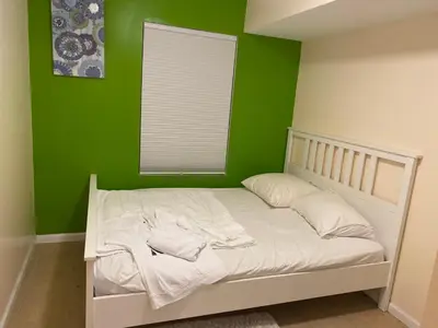 a green bedroom with a white bed with a window at The Green Place of Newark in Newark