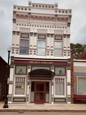 a tall white building with a sign for the cast iron lobby at The Cast Iron Lady in Wyalusing