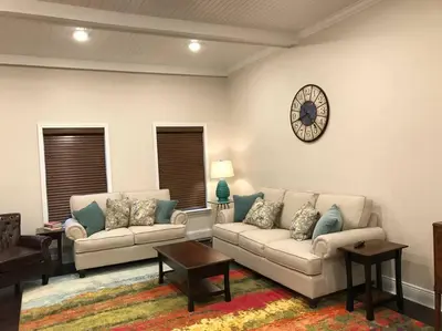 a living room with two couches and a clock on the wall at The Cast Iron Lady in Wyalusing