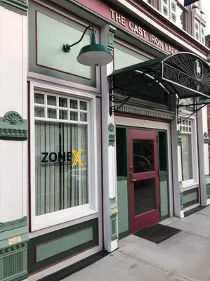 a store front with a red door on a street at The Cast Iron Lady in Wyalusing