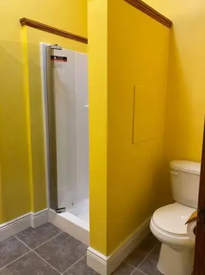 a yellow bathroom with a toilet and a shower at Small Town Hideaway in Wyalusing