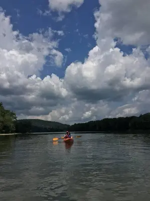 a person is in a kayak on a lake at Small Town Hideaway in Wyalusing