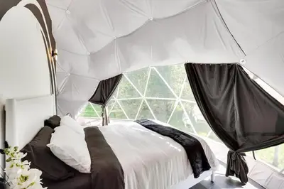 a bed in a room with a large window at Unique Escapes - 007 Geodome in Monticello