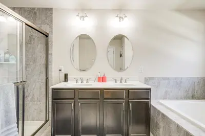 a bathroom with a sink and two mirrors at Spacious Ewing Township Home Home Gym and Deck!