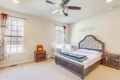 a bedroom with a crib and a ceiling fan at Spacious Ewing Township Home Home Gym and Deck!