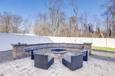 a patio with a fire pit in a backyard at Spacious Ewing Township Home Home Gym and Deck!