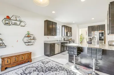 a kitchen with white walls and brown cabinets at Spacious Ewing Township Home Home Gym and Deck!