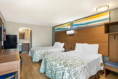 a hotel room with two beds and a flat screen tv at HomeTowne Studios by Red Roof Lancaster in Lancaster