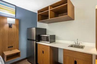 a kitchen with a stainless steel refrigerator and a sink at HomeTowne Studios by Red Roof Lancaster in Lancaster