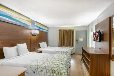 a hotel room with two beds and a desk at HomeTowne Studios by Red Roof Lancaster in Lancaster