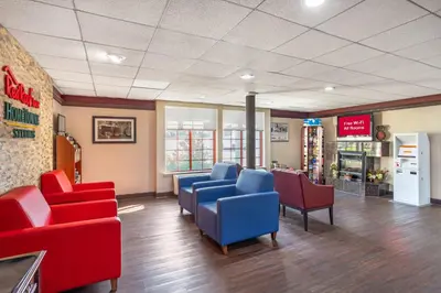 a waiting room with red and blue chairs in a store at HomeTowne Studios by Red Roof Lancaster in Lancaster